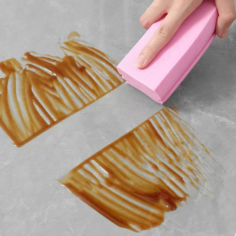 Person using a pink eraser to remove coffee stains from a white surface

